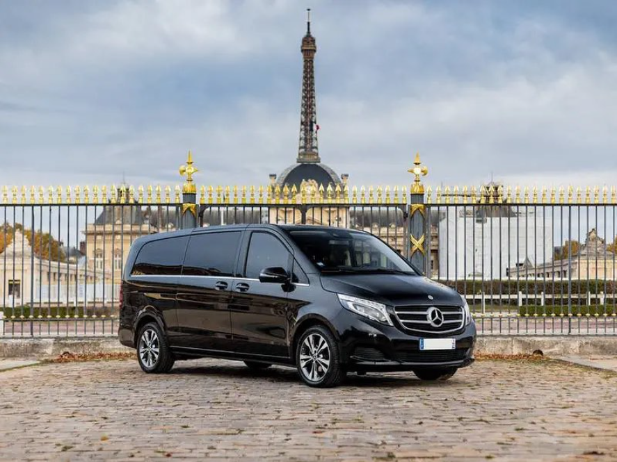 Véhicule de transport de personnes luxueux garé devant un portail à Paris